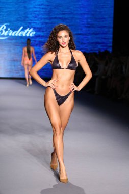 MIAMI BEACH, FLORIDA - 10 Temmuz 2021 'de Miami Beach, Florida' daki Paraiso Çadırı 'nda Bal Birdette için Miami Yüzme Haftası' nda bir model podyumda yürüyor..