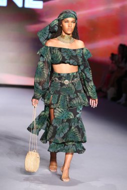 MIAMI BEACH, FLORIDA - 09 Temmuz 2021 'de Miami Beach, Florida' da bir model Bfyne Runway Show için podyumda yürüyor..