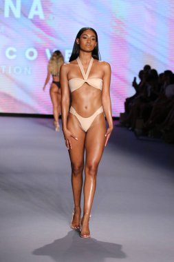 Miami Yüzme Haftası Paraiso Miami Sahili 'nde 9 Temmuz 2021' de Miami Beach, Florida 'da bir manken yeni yüzme markası Neena yüzüşü eşliğinde podyumda yürüyor..