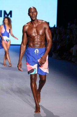 MIAMI BEACH, FLORIDA - 10 Temmuz 2021 'de Miami Beach, Florida' daki Paraiso Çadırı 'ndaki Miami Yüzme Haftası' nda Style Group Collective tarafından yapılan Yaşam sırasında bir model podyumda yürüyor..