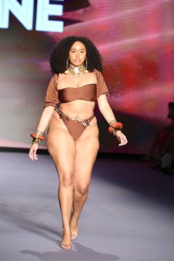 MIAMI BEACH, FLORIDA - 09 Temmuz 2021 'de Miami Beach, Florida' da bir model Bfyne Runway Show için podyumda yürüyor..