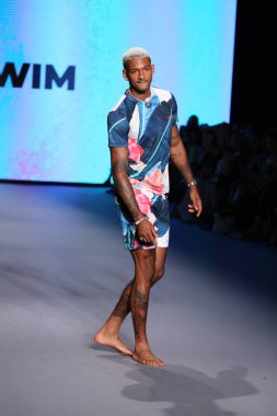 MIAMI BEACH, FLORIDA - 10 Temmuz 2021 'de Miami Beach, Florida' daki Paraiso Çadırı 'ndaki Miami Yüzme Haftası' nda Style Group Collective tarafından yapılan Yaşam sırasında bir model podyumda yürüyor..
