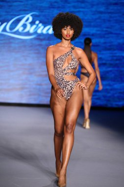 MIAMI BEACH, FLORIDA - 10 Temmuz 2021 'de Miami Beach, Florida' daki Paraiso Çadırı 'nda Bal Birdette için Miami Yüzme Haftası' nda bir model podyumda yürüyor..