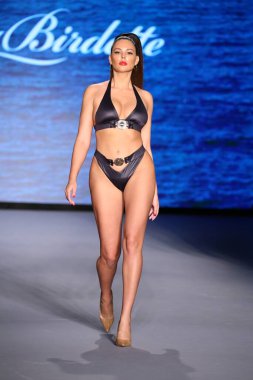MIAMI BEACH, FLORIDA - 10 Temmuz 2021 'de Miami Beach, Florida' daki Paraiso Çadırı 'nda Bal Birdette için Miami Yüzme Haftası' nda bir model podyumda yürüyor..