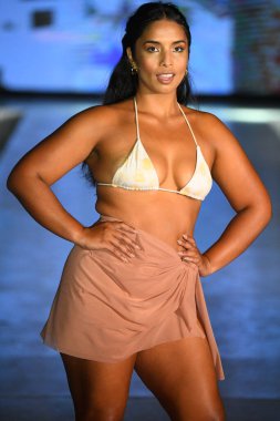 MIAMI BEACH, FLORIDA - 09 Temmuz 2021 'de Miami Beach, Florida' da DCSW tarafından desteklenen Miami Yüzme Haftası boyunca bir model neredeyse çıplak yüzme şovu için podyumda yürüyor.