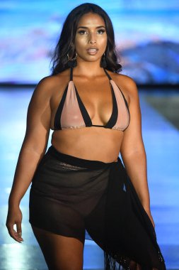 MIAMI BEACH, FLORIDA - 10 Temmuz 2021 'de Miami Beach, Florida' da DCSW tarafından desteklenen Miami Yüzme Haftası sırasında bir model gelinciklerle yüzmek için podyumda yürür.