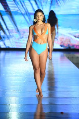 MIAMI BEACH, FLORIDA - 10 Temmuz 2021 'de Miami Beach, Florida' da DCSW tarafından desteklenen Miami Yüzme Haftası sırasında bir model gelinciklerle yüzmek için podyumda yürür.