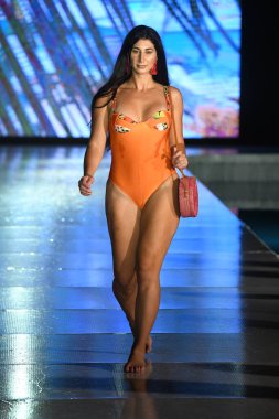MIAMI BEACH, FLORIDA - 10 Temmuz 2021 'de Miami Beach, Florida' da DCSW tarafından desteklenen Miami Yüzme Haftası sırasında bir model gelinciklerle yüzmek için podyumda yürür.
