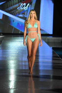 MIAMI BEACH, FLORIDA - 10 Temmuz 2021 'de Miami Beach, Florida' da DCSW tarafından desteklenen Miami Yüzme Haftası boyunca Swell Obsessed Swimwear Show için bir model podyumda yürüyor.