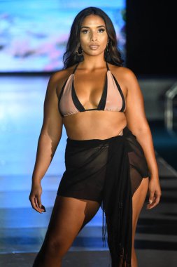 MIAMI BEACH, FLORIDA - 10 Temmuz 2021 'de Miami Beach, Florida' da DCSW tarafından desteklenen Miami Yüzme Haftası sırasında bir model gelinciklerle yüzmek için podyumda yürür.