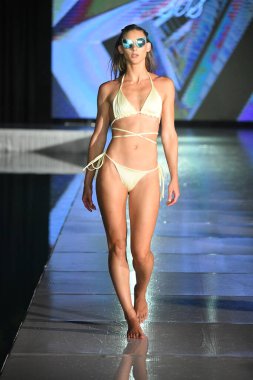 MIAMI BEACH, FLORIDA - 10 Temmuz 2021 'de Miami Beach, Florida' da DCSW tarafından desteklenen Miami Yüzme Haftası boyunca Swell Obsessed Swimwear Show için bir model podyumda yürüyor.