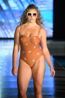 MIAMI BEACH, FLORIDA - 10 Temmuz 2021 'de Miami Beach, Florida' da DCSW tarafından desteklenen Miami Yüzme Haftası sırasında bir model gelinciklerle yüzmek için podyumda yürür.