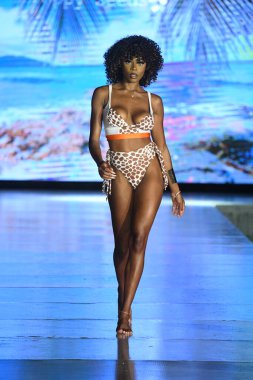 MIAMI BEACH, FLORIDA - 10 Temmuz 2021 'de Miami Beach, Florida' da DCSW tarafından desteklenen Miami Yüzme Haftası sırasında bir model gelinciklerle yüzmek için podyumda yürür.