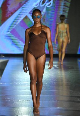 MIAMI BEACH, FLORIDA - 10 Temmuz 2021 'de Miami Beach, Florida' da DCSW tarafından desteklenen Miami Yüzme Haftası boyunca Swell Obsessed Swimwear Show için bir model podyumda yürüyor.