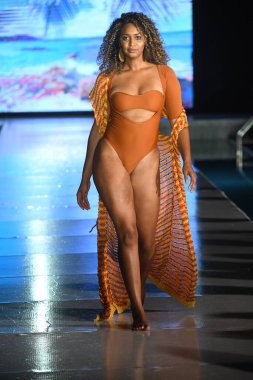 MIAMI BEACH, FLORIDA - 10 Temmuz 2021 'de Miami Beach, Florida' da DCSW tarafından desteklenen Miami Yüzme Haftası sırasında bir model gelinciklerle yüzmek için podyumda yürür.