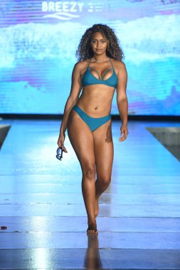 MIAMI BEACH, FLORIDA - 10 Temmuz 2021 'de Miami Yüzme Haftası sırasında Miami Beach, Florida' da bir model Breezy Swimwear Show için podyumda yürür.