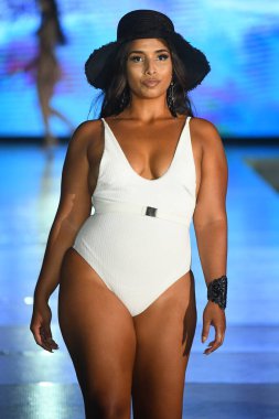 MIAMI BEACH, FLORIDA - 10 Temmuz 2021 'de Miami Yüzme Haftası sırasında Miami Beach, Florida' da bir model Breezy Swimwear Show için podyumda yürür.