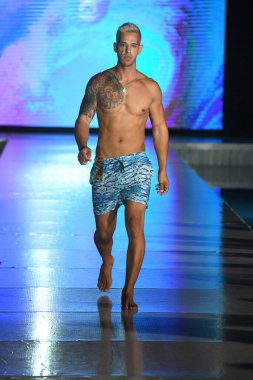 MIAMI BEACH, FLORIDA - 10 Temmuz 2021 'de Miami Beach, Florida' da bir model Miami Yüzme Haftası boyunca Mar Ardiente Yüzme Gösterisi için podyumda yürür.