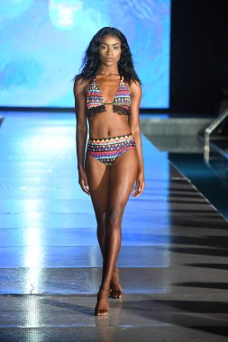 MIAMI BEACH, FLORIDA - 10 Temmuz 2021 'de Miami Beach, Florida' da bir model Miami Yüzme Haftası boyunca Mar Ardiente Yüzme Gösterisi için podyumda yürür.