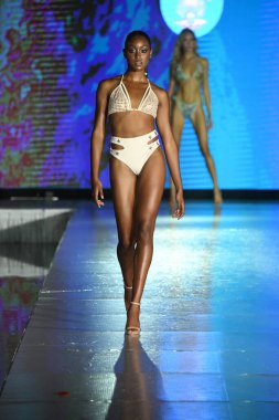MIAMI BEACH, FLORIDA - 10 Temmuz 2021 'de Miami Beach, Florida' da bir model Miami Yüzme Haftası boyunca Mar Ardiente Yüzme Gösterisi için podyumda yürür.