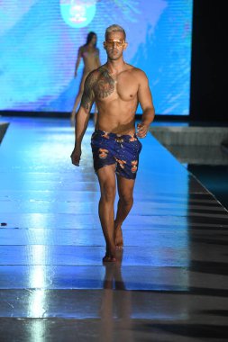 MIAMI BEACH, FLORIDA - 10 Temmuz 2021 'de Miami Beach, Florida' da bir model Miami Yüzme Haftası boyunca Mar Ardiente Yüzme Gösterisi için podyumda yürür.