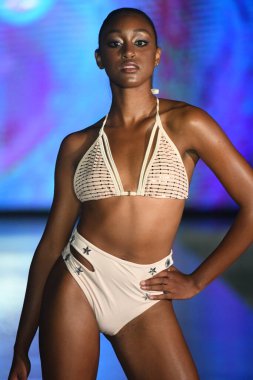 MIAMI BEACH, FLORIDA - 10 Temmuz 2021 'de Miami Beach, Florida' da bir model Miami Yüzme Haftası boyunca Mar Ardiente Yüzme Gösterisi için podyumda yürür.