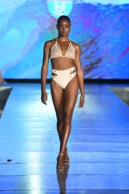 MIAMI BEACH, FLORIDA - 10 Temmuz 2021 'de Miami Beach, Florida' da bir model Miami Yüzme Haftası boyunca Mar Ardiente Yüzme Gösterisi için podyumda yürür.