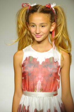 Model, Alivia Simone ön gösterimi sırasında küçük geçit töreninde podyumda yürüyor.