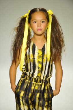 Model, Alivia Simone ön gösterimi sırasında küçük geçit töreninde podyumda yürüyor.