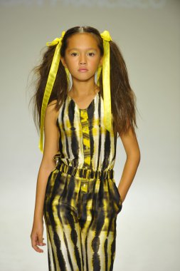 Model, Alivia Simone ön gösterimi sırasında küçük geçit töreninde podyumda yürüyor.