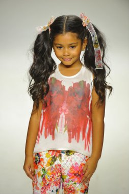 Model, Alivia Simone ön gösterimi sırasında küçük geçit töreninde podyumda yürüyor.