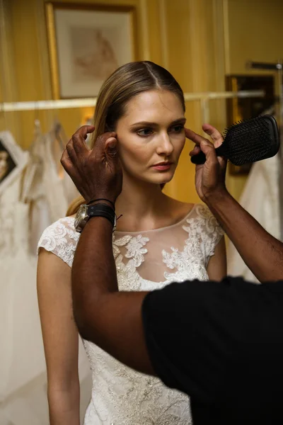 Model getting ready backstage wearing Oleg Cassini Fall 2015 Bridal collection