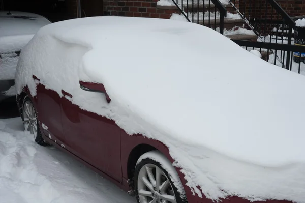 NEW YORK JANUARY 27: A car remains buried in the snow on Emmons Ave in the Broooklyn, New York on Tuesday, January 27, 2015, the day after the snow blizzard of 2015. — Stock Photo, Image