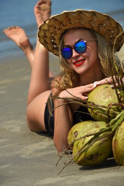 Kadın kumsalda yatıyor.