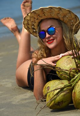 Kadın kumsalda yatıyor.