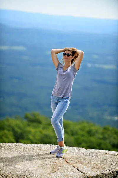 Mujer joven posando en el borde de la roca — Foto de Stock