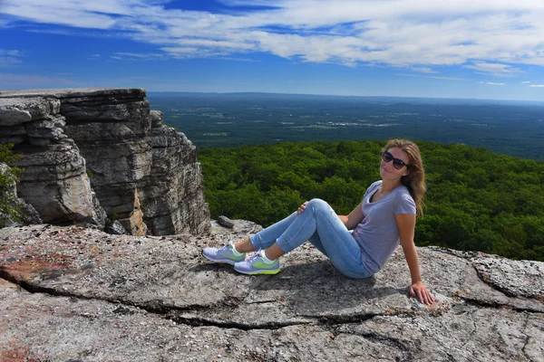 Woman sitting at the edge of rock — Stock Photo, Image