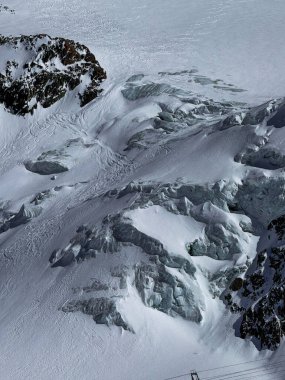 Zermatt yakınlarındaki İsviçre Alplerinde dramatik kayalık tepeleri olan karlı buzullar. Kış manzarası parlak güneş ışığı altında