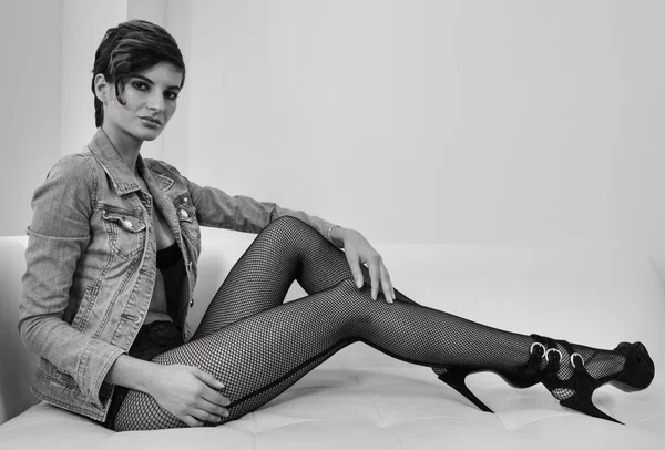 Model zittend op de Bank en benen weergegeven: — Stockfoto
