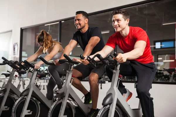 Amigos y una mujer haciendo algo de spinning —  Fotos de Stock