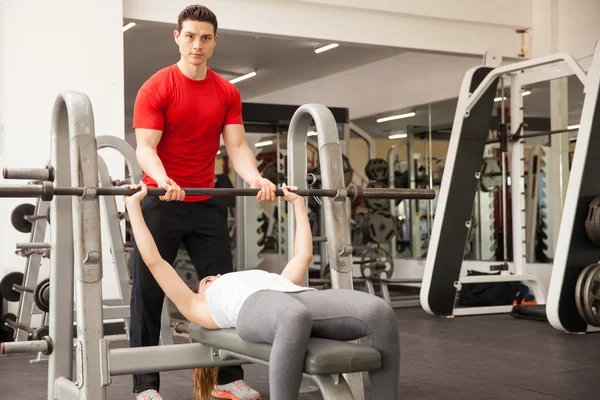 Personal trainer spotting a woman — Stock Photo, Image