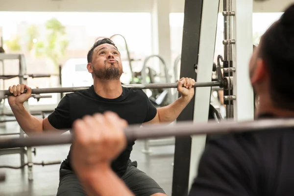 Man using a squat machine — Stock Photo, Image