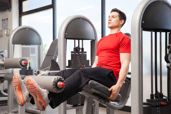 Man focused on his leg extensions — Stock Photo, Image