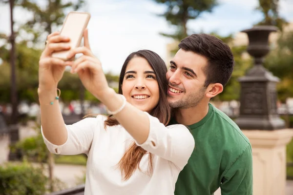 Casal hispânico tomando uma selfie — Fotografia de Stock