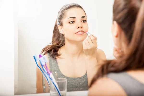 Vrouw zetten sommige lippenstift — Stockfoto