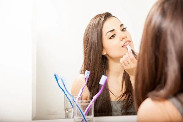 Vrouw zetten sommige lippenstift op — Stockfoto