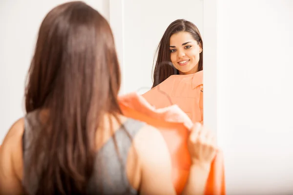 Kvinde kontrollere, hvordan en bluse ser ud - Stock-foto
