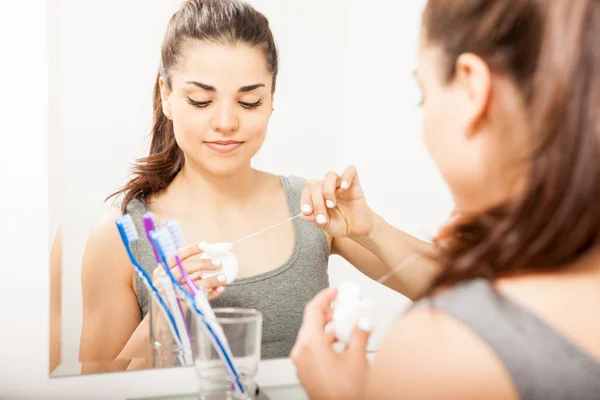 Mujer agarrando hilo dental — Foto de Stock