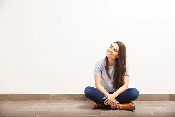 Brunette zittend op de vloer — Stockfoto