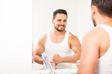 genç adam bir banyo aynası önünde ayakta 